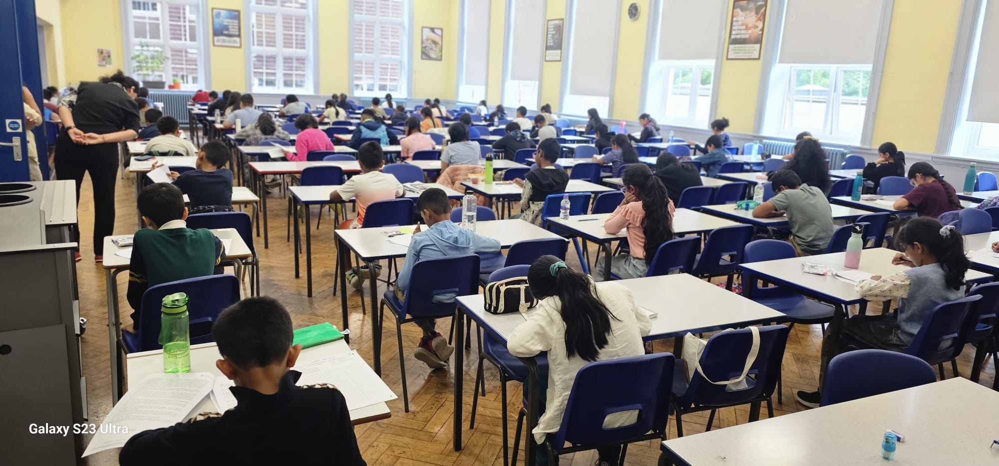 Children focused on exam papers during a GLECTA mock test